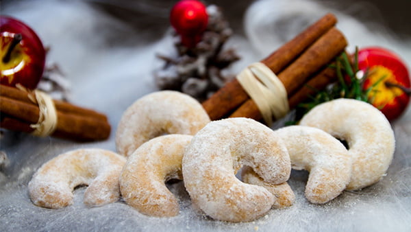 Vanillekipferl mit Zimstangen Äfpeln und Tannenzapfen als Weihnachtsdeko