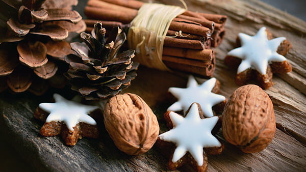 Zimtsterne Plätzchen mit Walnüssen und Zimt in Tannenzapfen Deko zu Weihnachten