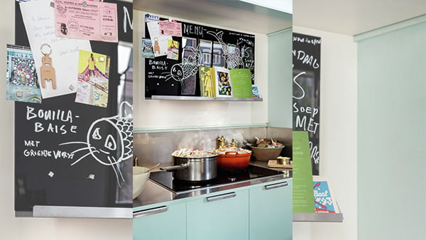 Moderne Küche mit beschrifteter dunkler Tafeloberfläche und Magneten auf einer Neff Collection Dunstabzugshaube mit Ablagefläche