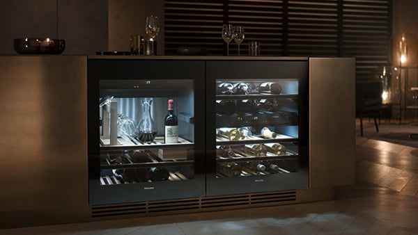 kleiner weinschrank von miele mit licht in verdunkeltem raum