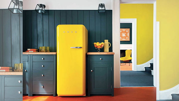 gelber smeg retro kühlschrank in grau grüner küche mit rotem teppichboden