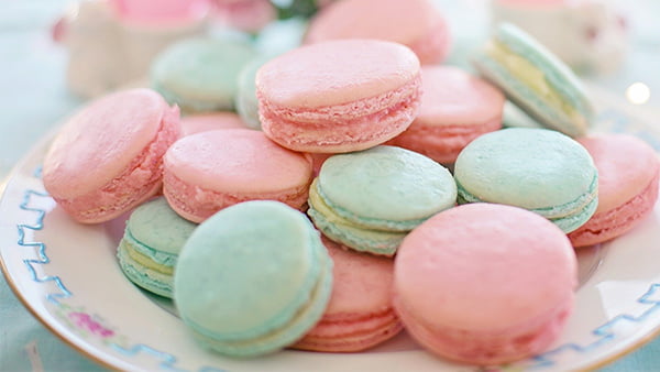 rosa und grüne pastell macarons mit himbeer und pistaziengeschmack auf einem teller