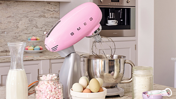 pastell rosa küchenmaschine von smeg in einer küche mit zutaten zum backen