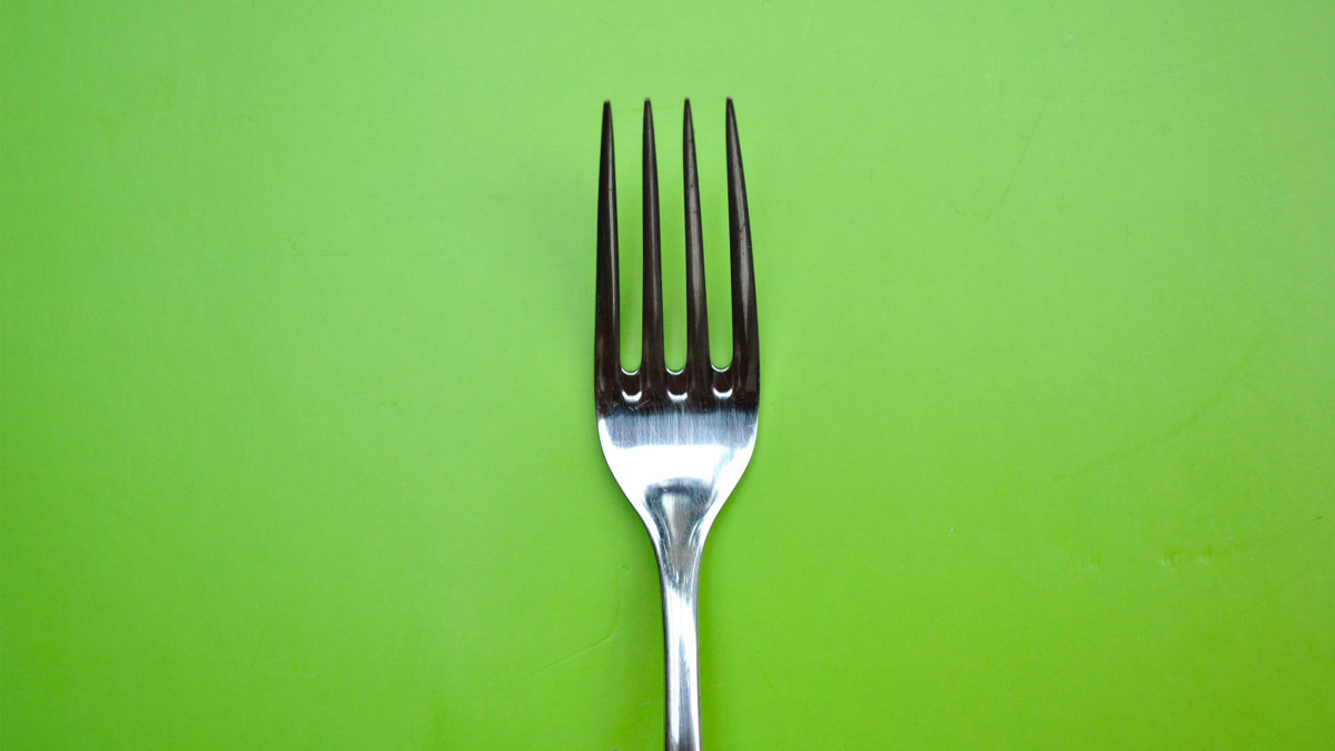 veganismus symbolbild gabel mit grünem hintergrund