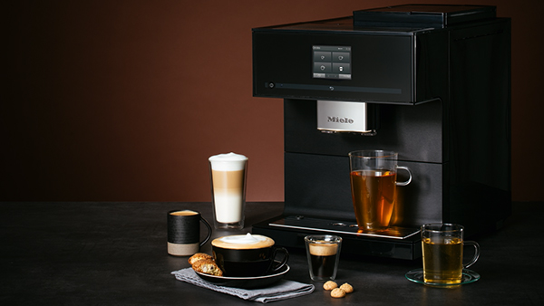 miele stand kaffeevollautomat mit verschiedenen heißgetränken wie tee und milchkaffee