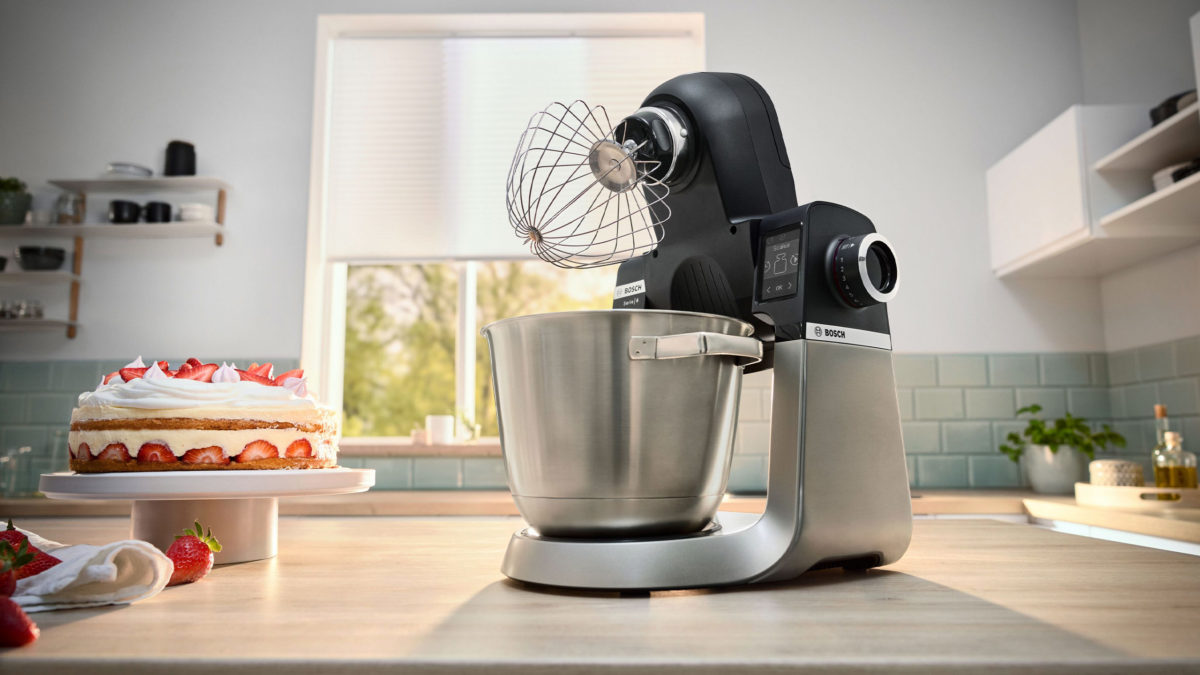 bosch serie 6 küchenmaschine mit schneebesen neben einer erdbeersahnetorte