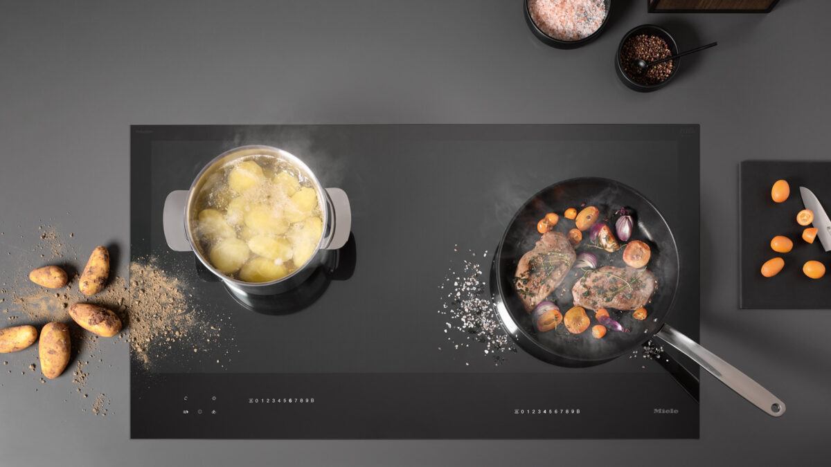 topf und pfanne auf einem miele diamond induktionskochfeld neben salz und kartoffeln von oben