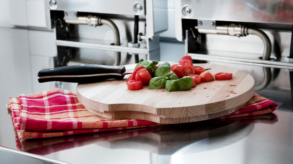 Holz schneidbrett mit tomaten in der alpes inox edelstahlküche