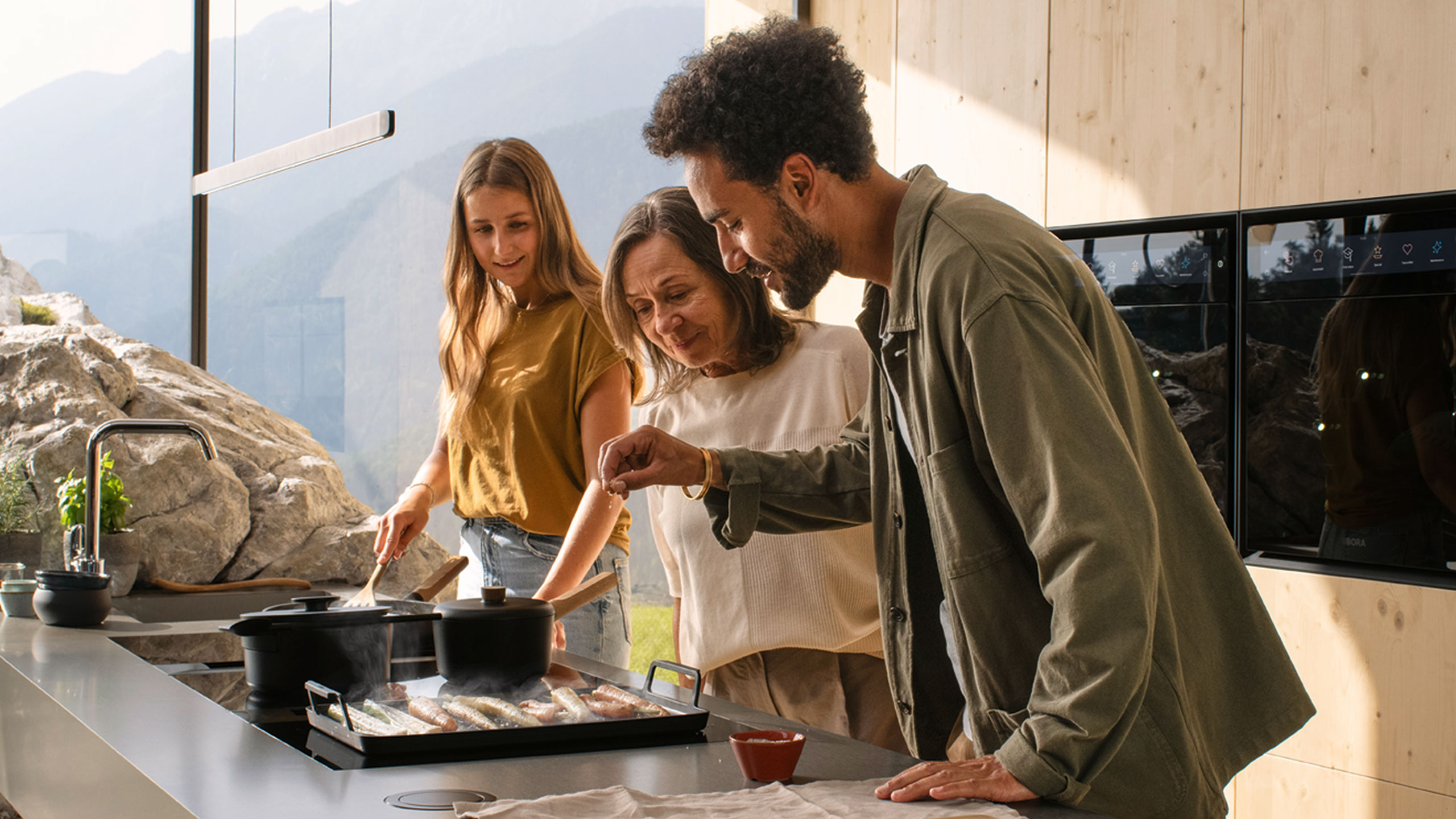 drei personen beim kochen am bora kochfeld