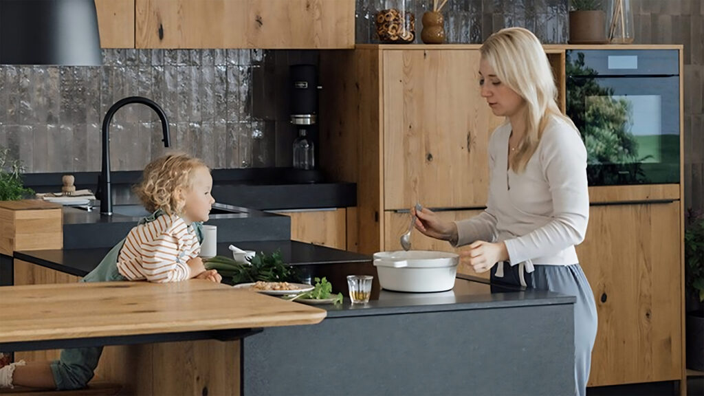 frau und kind beim kochen in einer walden naturholzküche