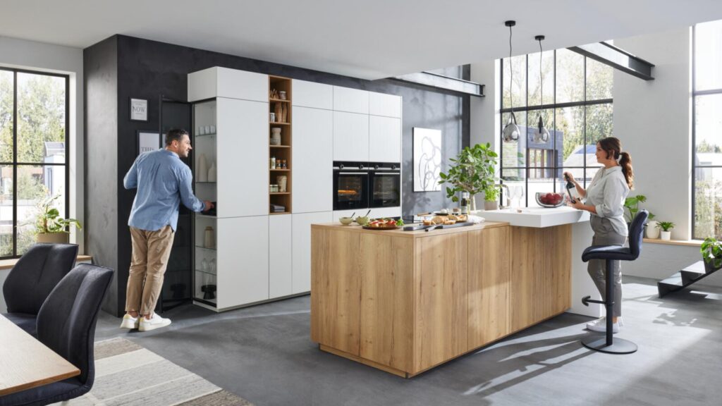 Loftartige Interliving Küche mit weißer Schrankwand und Kochinsel in Holzoptik bei Küchen Staude Hannover