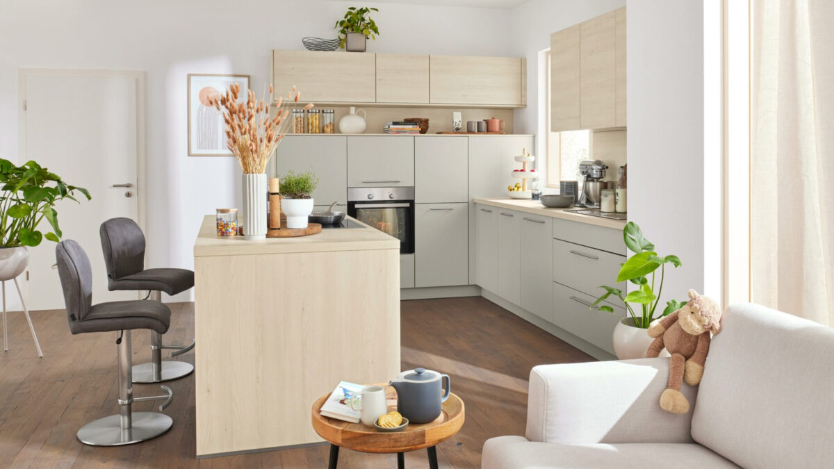 Interliving Wohnküche mit heller Kücheninsel und Barhockern bei Küchen Staude in Hannover