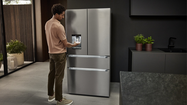 mann zieht eiswürfel aus dem icemaker im liebherr french door kühlschrank