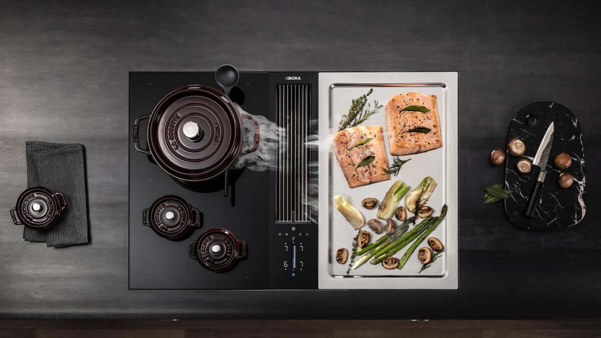 bora kochfeld mit teppanyaki, auf dem lachs und gemüse grillen