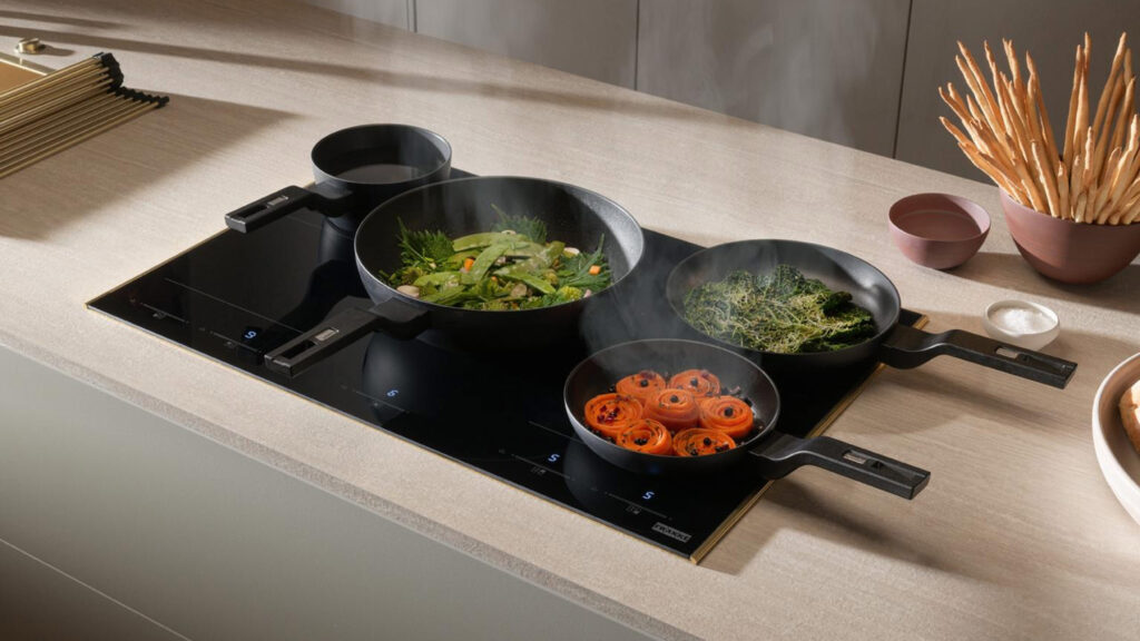 mehrere pfannen mit gemüse auf dem franke mythos masterpiece kochfeld