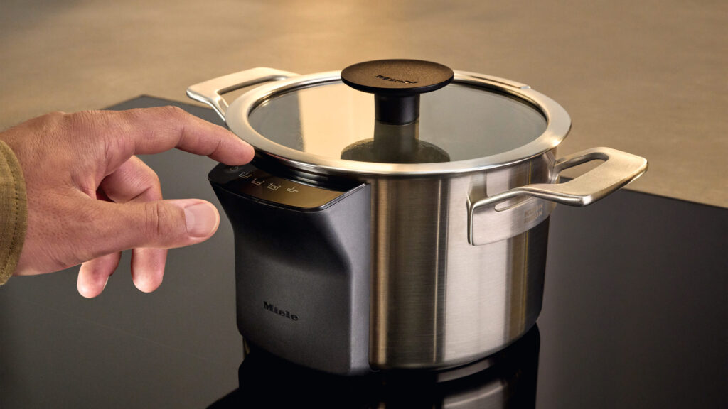 mann berührt den sensor am miele m sense topf mit deckel