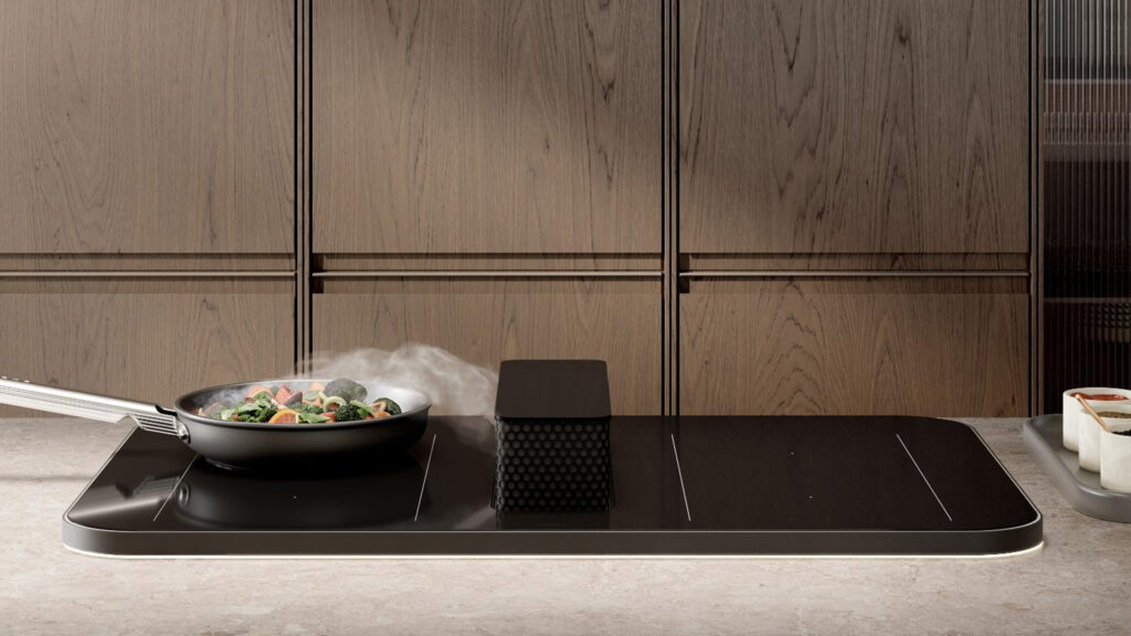 dunstabzug am smeg isola kochfeld saugt kochdunst vom gemüse braten in einer pfanne ab